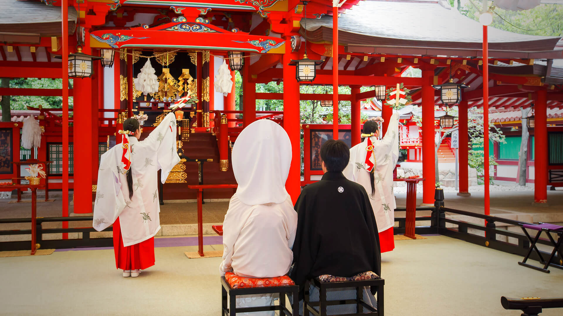 朱塗りの本殿を進む花嫁