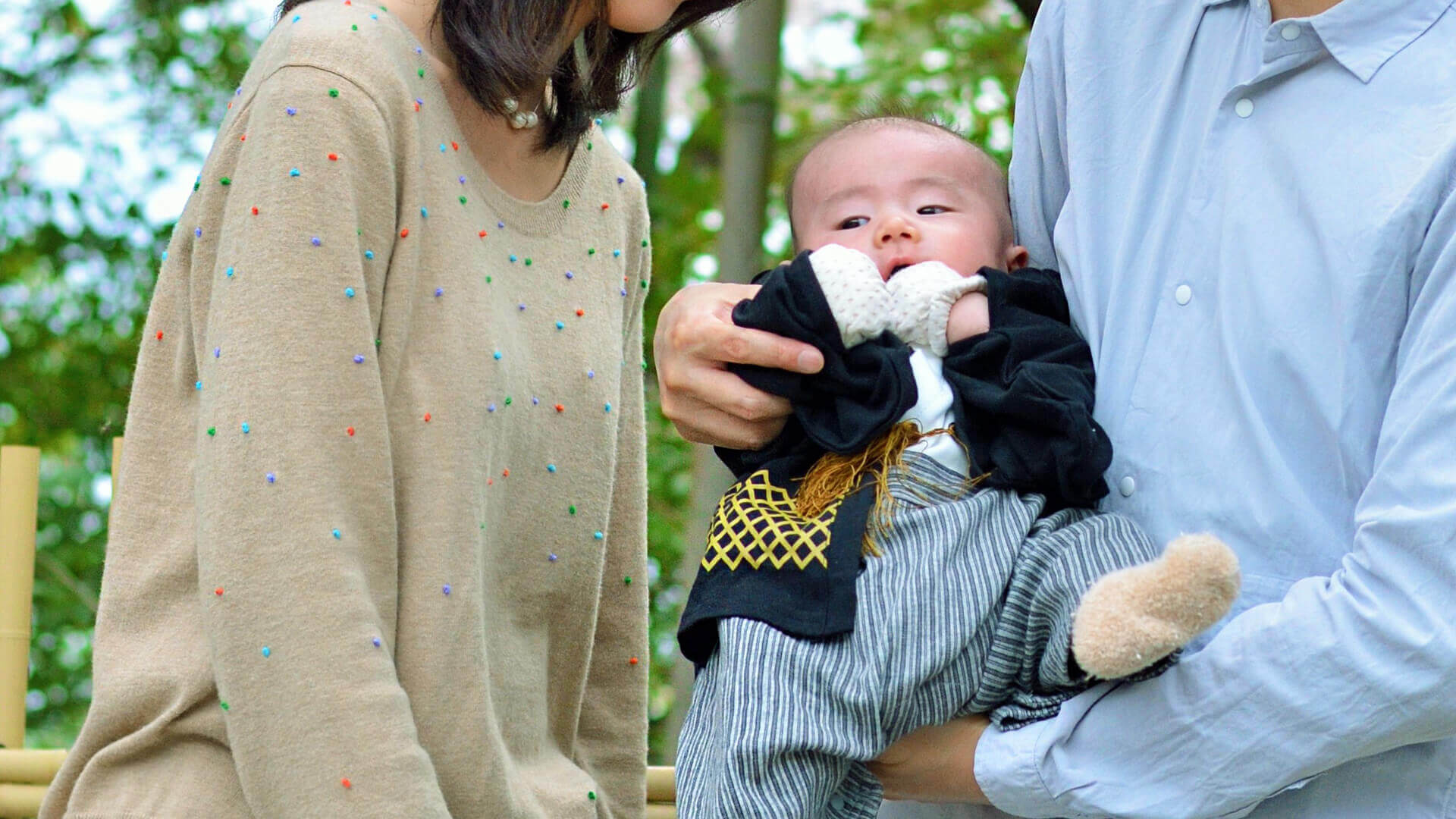 赤ちゃんを抱いてお宮参りをするご家族
